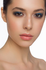 Fototapeta premium Close-up beauty portrait of a young girl with brown eyes and blue eyes on her beautiful eyes. Fashionable photo of a brunette with full lips and a natural blush on her cheeks. Spa and cosmetology