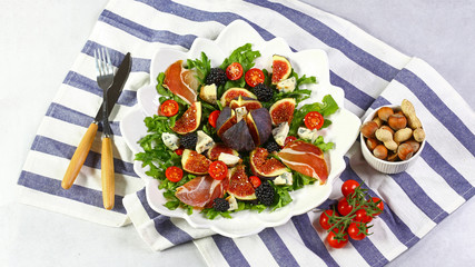 Easy vegetarian salad with figs, strawberries, grapes, blue cheese Dorblu and lettuce. Flat lay. Top view