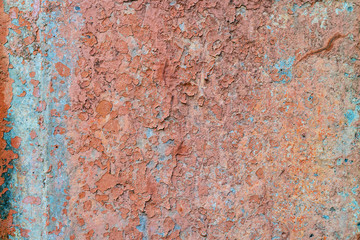 an old painted wall with pealing blue and orange paint