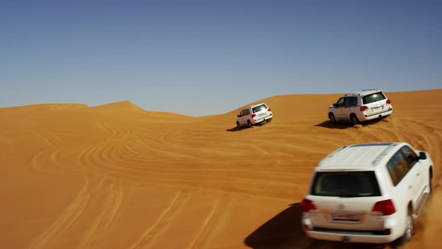 Aerial Dubai Drone view of Desert Safari vehicles dune bashing