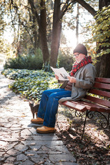 Smart aged man reading a newspaper in the park