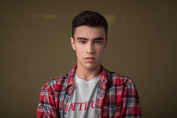 The portrait of young white boy looking camera posing isolated over green wall background