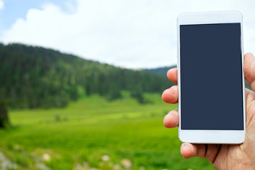 man uses phone in mountains