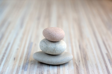 Stone cairn on striped grey white background, three stones tower, simple poise stones, simplicity harmony and balance, rock zen