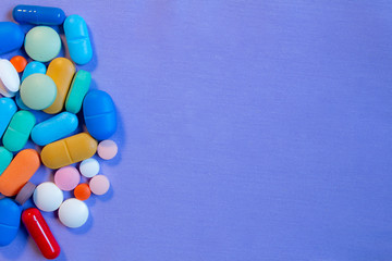 Colorful pills on neutral blue background