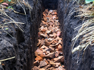 Broken brick piled to the bottom of the trench