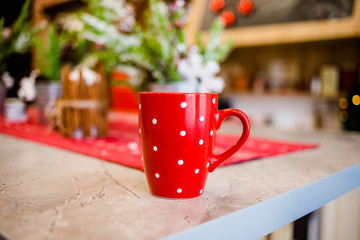 The sweet red cup is on the table