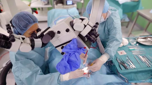 Shot from above of group of surgeons on a hearing correction surgery.