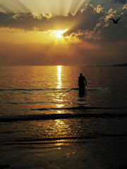 Man bathing in the sea at sunset
