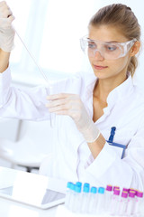 Female scientific researcher or blood test assistant at work in laboratory. Science, medicine and pharmacy concept