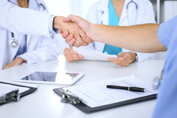 Two doctors shaking hands to each other at meeting. Teamwork and agreement in medicine