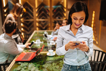 Young woman looking at the phone at a business meeting