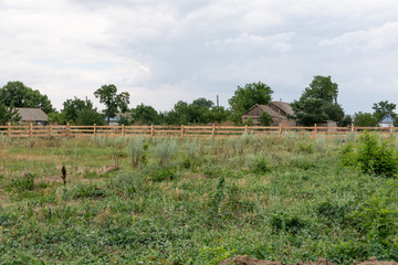 Obraz premium Ranch style fence. Rural wooden fence on green grass at farm ranch land in Shagany, Ukraina.