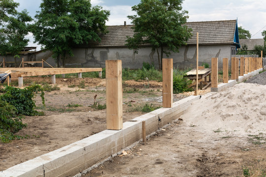 Concrete Foundation For Fence. Production Of The Concrete Base For A Wooden Fence.