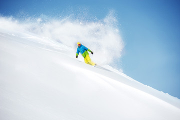 Naklejka na ściany i meble Fast snowboarder at offpiste with powder