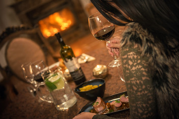 pretty woman drinking red wine and eating in restaurant, winter time, romantic dinner
