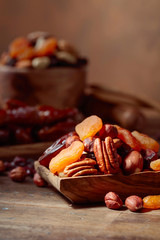 Various dried fruits and nuts in wooden dish.