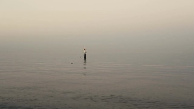 Calm sea with small ripples and buoy floating on a water surface