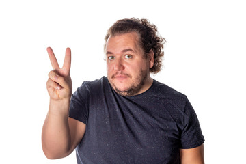 Fototapeta premium Portrait of funny fat man showing peace v-sign or victory gesture on white background
