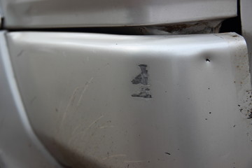 Small damage to the bumper of a gray silver car as a result of an accident - a violation of fastening, dent, scratches