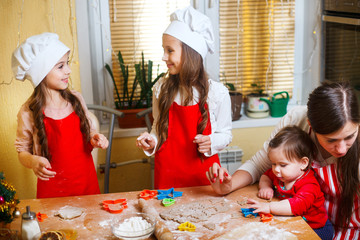 Family with children preparing cookies for Xmas in kitchen