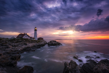 Sunshine breaking through dark clouds at Portland Head Lighthouse in Maine