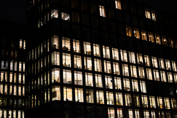 Office building with many lit windows at night in the city