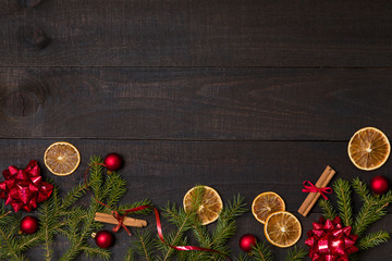 Dark rustic wooden table background with Christmas decoration and fir frame. Top view with free space for copy text