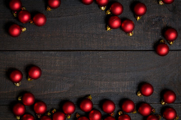 Naklejka na ściany i meble Dark rustic wooden table background with red Christmas ornament frame. Top view with free space for copy text