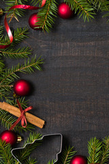 Dark rustic wooden table background with Christmas decoration and fir frame. Top view with free space for copy text