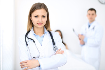 Fototapeta premium Medicine doctor standing and smiling on the background with patient in the bed