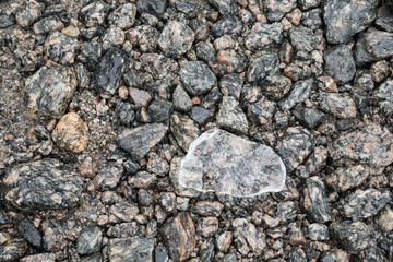 stück eis auf kieselsteinen aus Granit