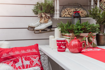 Knitted red cup with white reindeer on table with Christmas decoration background, winter morning...