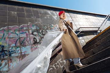 Stylish skinny fashion model posing wearing beige coat and red beret