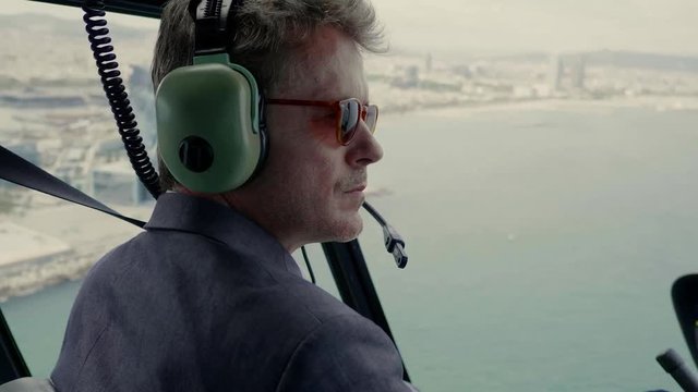 Business man sitting inside a cabin of helicopter