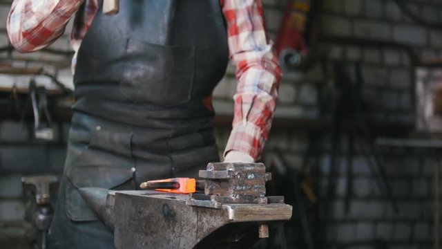 Blacksmith workroom. Making a perfect form detail using a hammer and a chisel