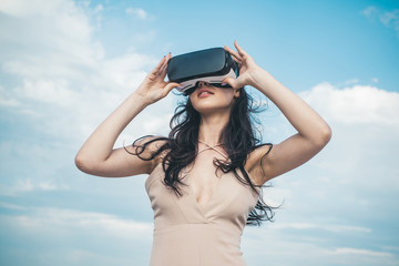 Girl using VR headset. Woman getting experience using VR-headset glasses. Visual reality concept. Digital future and innovation. Woman with glasses of virtual reality. Cool. Enjoying new experience