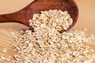 Oat flakes in a wooden spoon on the wooden Table