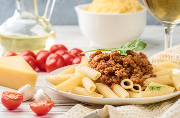 Italian pasta bolognese from pasta penne rigatone minced meat in tomato sauce and parmesan cheese