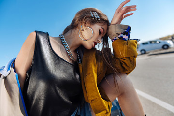 Dark-haired model wearing silver earrings and black leather shirt