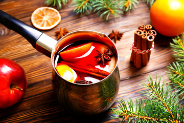 Christmas composition with mulled wine with its ingredients & spices on wooden textured table....