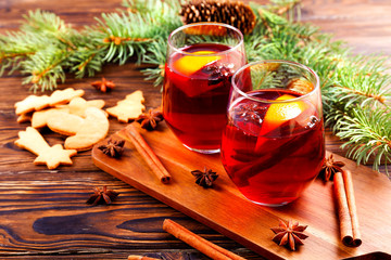 Christmas composition with mulled wine with its ingredients & spices on wooden textured table....