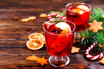 Christmas composition with mulled wine with its ingredients & spices on wooden textured table....