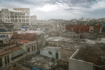 Obraz premium Panoramic view over the rooftops of Havana City in Cuba. The run-down buildings mostly in colonial style provide a special flair for visitors and tourists. Sun stream and lens flare included.