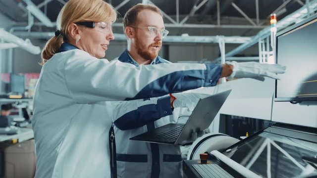 On Tech Factory Female, Male Engineers Talk, Use Computer for Programming Pick n Place Electronic Machinery for Printed Circuit Board Surface Mount Assembly Line