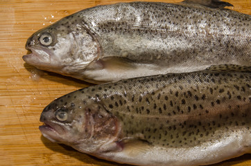 Rainbow trout fish on wooden table ready for cooking stuffed with lemon
