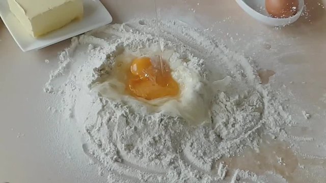 preparing a cake - the egg falls into flour - filmed in slow motion