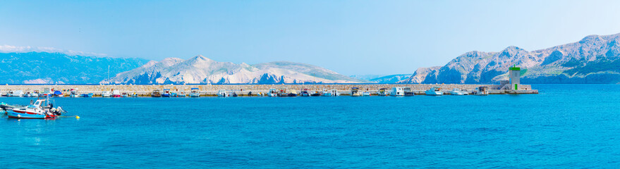 Wonderful romantic summer afternoon landscape panorama coastline Adriatic sea. Boats and yachts in harbor at cristal clear turquoise water. Baska on the island of Krk. Croatia. Europe.