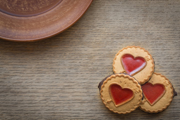 Heart shaped Valentines Day cookies with jam on dark wooden background. Top view. Copy space. Decorative background of heart. Design elements for Valentine's Day, Mother's day or Birthday