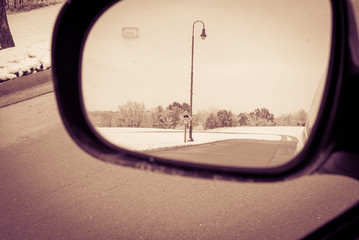 View from rear view mirror of road sign while driving